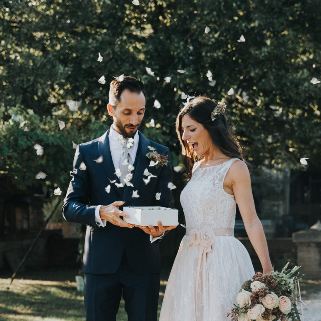Sposi liberano farfalle bianche da una scatola durante il matrimonio